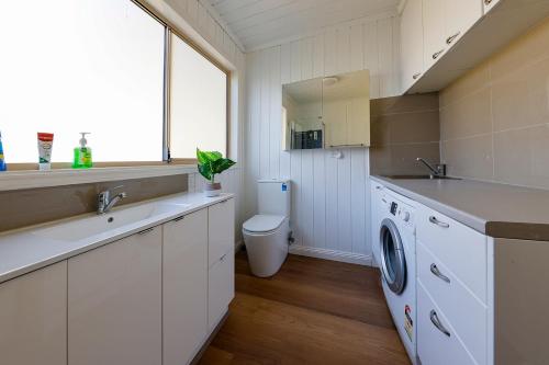 a bathroom with a sink and a washing machine at caplesound stays in Capel Sound
