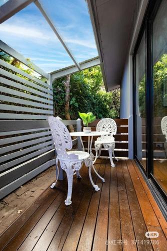 a patio with two chairs and a table on a porch at caplesound stays in Capel Sound