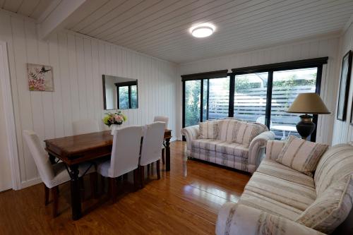 a living room with a table and chairs and a couch at caplesound stays in Capel Sound