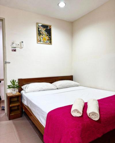 a bedroom with a large bed with a red blanket at Town Inn Hotel - Rainforest in Jerantut