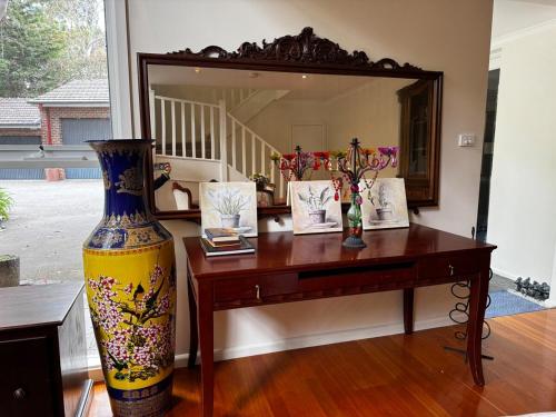 a vase sitting on a table in front of a mirror at Granny Unit Self Contained Double Storage WIFI POOL PARKING in Templestowe
