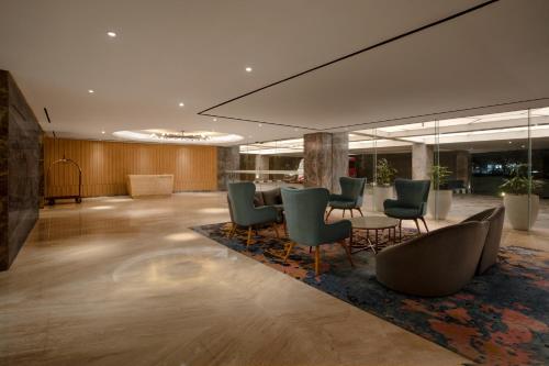 an office lobby with chairs and a table at Grand Orchardz Hotel Kemayoran Jakarta in Jakarta