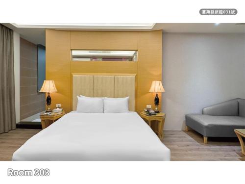 a bedroom with a large bed and a couch at Milan Motel in Miaoli