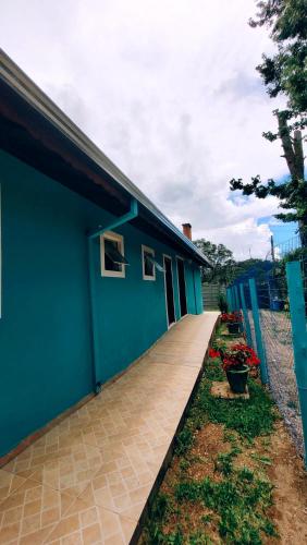 a blue building with a sign on the side of it at Cantinho Dona Cleide in Monte Verde