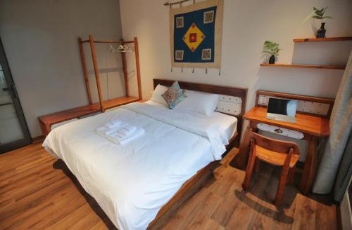 a bedroom with a bed and a desk with a laptop at Kim House Boutique Hotel Da Nang in Da Nang