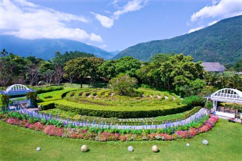 a garden with flowers and a hedge at Gaeavilla Resort in Jian