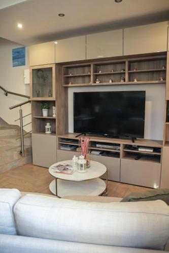 a living room with a large television and a white couch at Giorgia House in Pieta