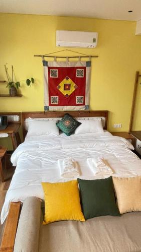 a bedroom with a large white bed with yellow pillows at Kim House Boutique Hotel Da Nang in Da Nang