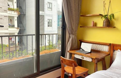 a bedroom with a desk and a window with a laptop at Kim House Boutique Hotel Da Nang in Da Nang