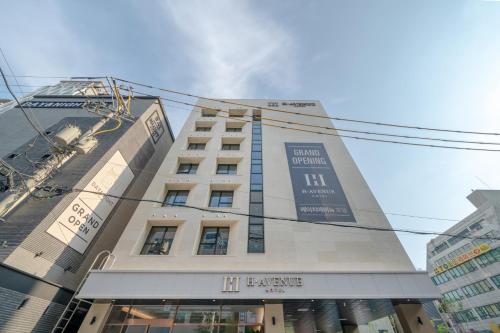 a tall white building with a sign on it at H avenue Incheon Seogu in Incheon