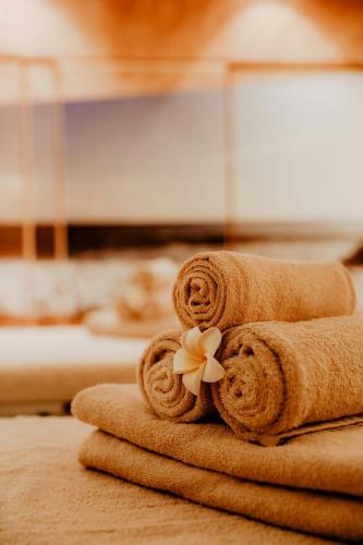 a pile of towels with a flower on top at Le Méridien Stuttgart in Stuttgart