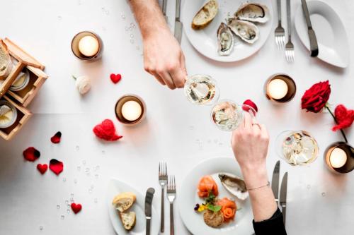a table with plates of food and people holding wine glasses at Le Méridien Stuttgart in Stuttgart
