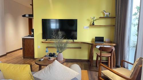a living room with a flat screen tv and a table at Kim House Boutique Hotel Da Nang in Da Nang
