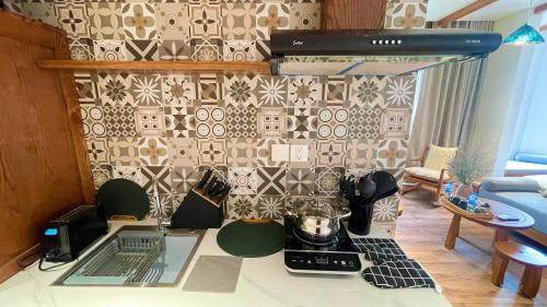a kitchen with a stove and a patterned wall at Kim House Boutique Hotel Da Nang in Da Nang