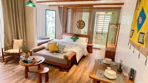 a bedroom with a bed and a couch and a table at Kim House Boutique Hotel Da Nang in Da Nang