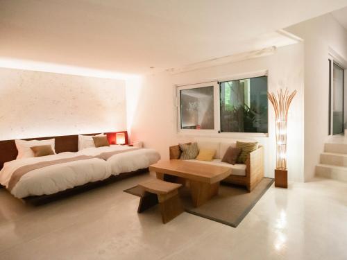 a bedroom with a bed and a couch and a table at Jusandi in Ishigaki Island