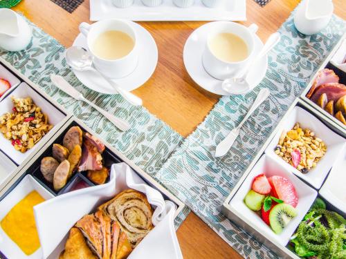 a table topped with trays of food and cups of coffee at Jusandi in Ishigaki Island