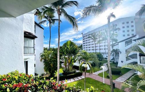 a view of a courtyard with palm trees and a building at Villa Marina in Puerto Vallarta