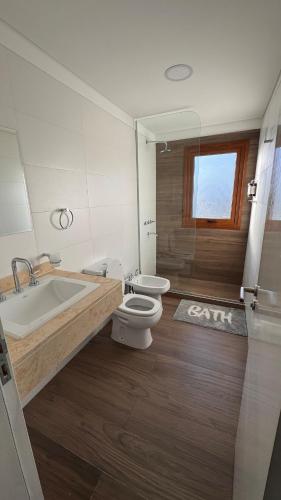 a bathroom with a toilet and a tub and a sink at Vista Montañas y Viñas in Cafayate