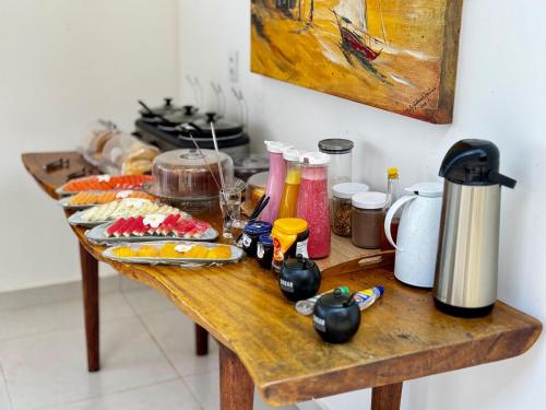 a wooden table with food on top of it at Caly Pousada in São Miguel do Gostoso