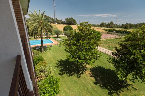 a view of a yard with a swimming pool and trees at Hotel Sausa in Vilafreser
