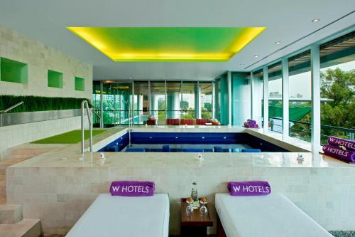 a swimming pool in a house with windows at W Mexico City in Mexico City