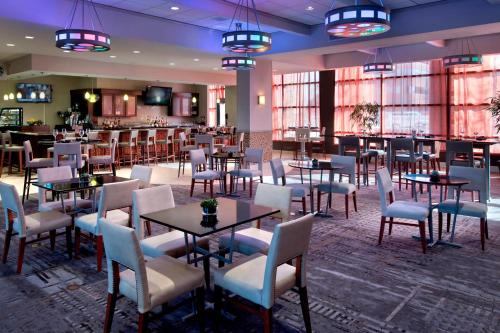 a restaurant with tables and chairs and a bar at Marriott Albany in Albany