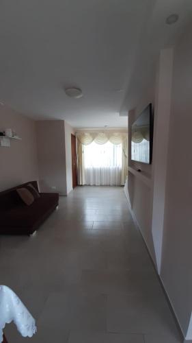 a living room with a couch and a flat screen tv at Apartamento Moderno y Nuevo in Baños