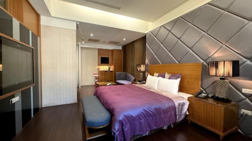 a hotel room with a bed and a television at Milan Motel in Miaoli