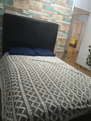 a bed in a room with a brick wall at Morada Quetzalcoatl in San Juan Teotihuacán