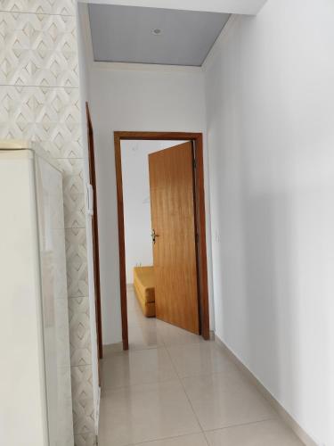 a hallway with a door in a white room at Apartamento kit aconchegante 3 in Matinhos