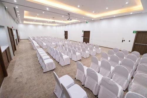 an empty room with white chairs and tables at Holiday Inn Uruapan by IHG in Uruapan del Progreso