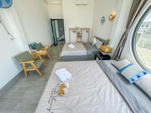 a hotel room with two beds and a window at Dứa Homestay in Cu Lao Thu
