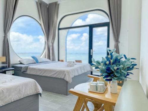 a hotel room with two beds and a table with flowers at Dứa Homestay in Cu Lao Thu