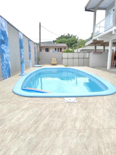 a large blue swimming pool in a yard at Apartamento kit aconchegante 3 in Matinhos