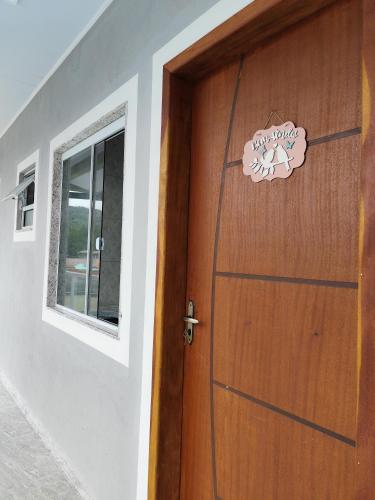 a wooden door with a sign that reads happy holidays at Apartamento kit aconchegante 3 in Matinhos
