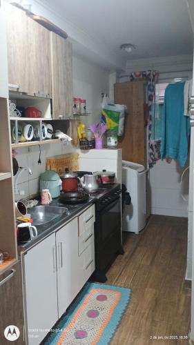 uma pequena cozinha com fogão e geladeira em hostel praia dos ingleses em Florianópolis