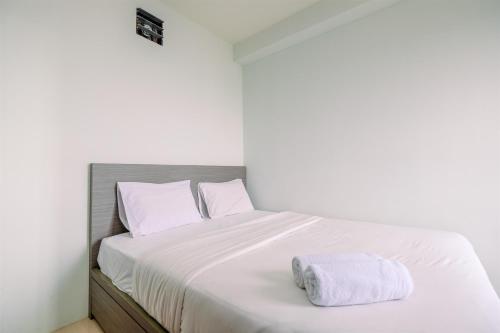 Una cama o camas en una habitación de Combined 2BR with Study Room Titanium Square Apartment By Travelio