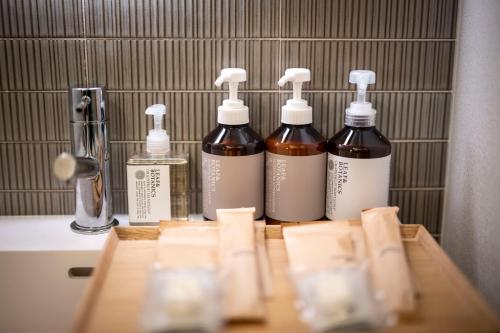 a group of four bottles on a bathroom counter at Tanuki Nozawa in Nozawa Onsen