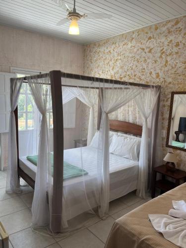 a bedroom with a bed with a canopy at Pousada Canavieiras Frederic in Canavieiras