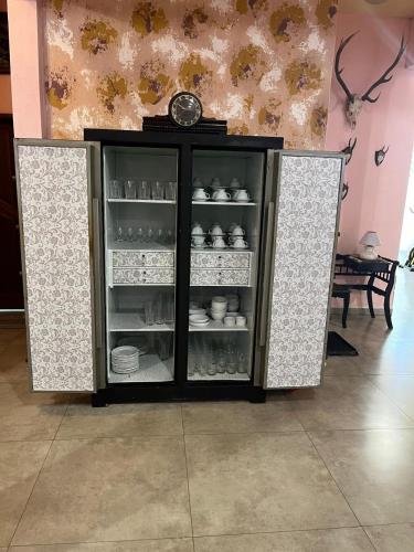 a glass cabinet with a clock on top of it at Pousada Canavieiras Frederic in Canavieiras