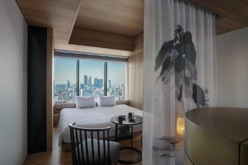 a bedroom with a bed and a view of a city at The Royal Park Hotel Iconic Nagoya in Nagoya