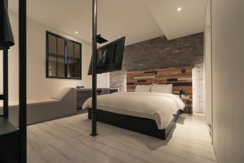 a bedroom with a bed and a television in it at Hotel Yaja Siheung Jeongwang in Siheung