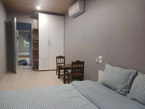 a bedroom with a bed and a table and chairs at Halo Retreat in Hòa Bình