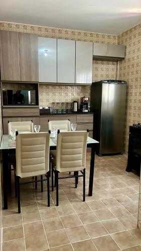 a kitchen with a table and chairs and a refrigerator at Casa com excelente localização! in São Roque