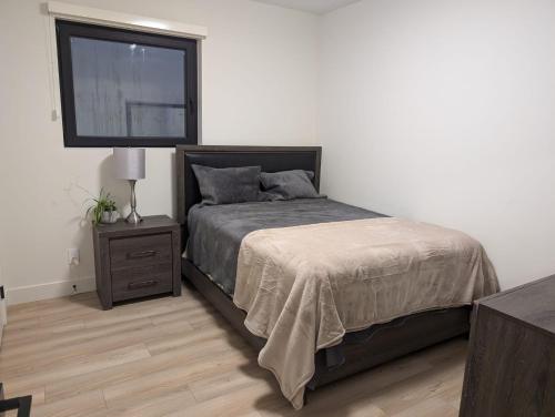 a bedroom with a bed and a flat screen tv at Beautiful 2 Bedroom suite in White Rock