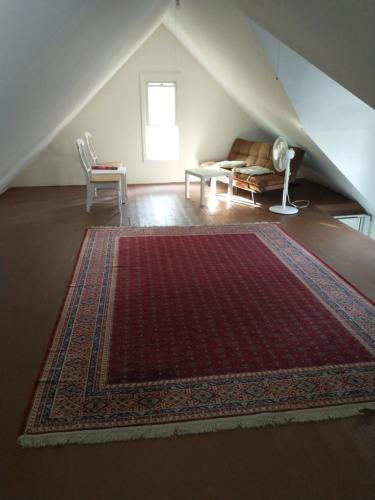 an attic room with a rug on the floor and a couch at Comfortable 3 Bedroom Apartment 30 Minutes to New York in Pfister Helistop