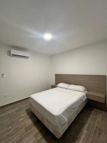 a bedroom with a large bed with white sheets at Casa Japandi in Manta