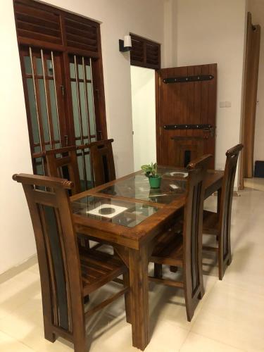 a dining room table and chairs with a glass top at Lanka Villa Mirissa in Mirissa