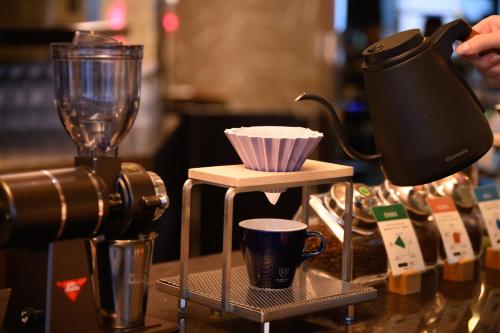 a coffee maker and a cup on a counter at The Royal Park Canvas - Osaka Kitahama in Osaka